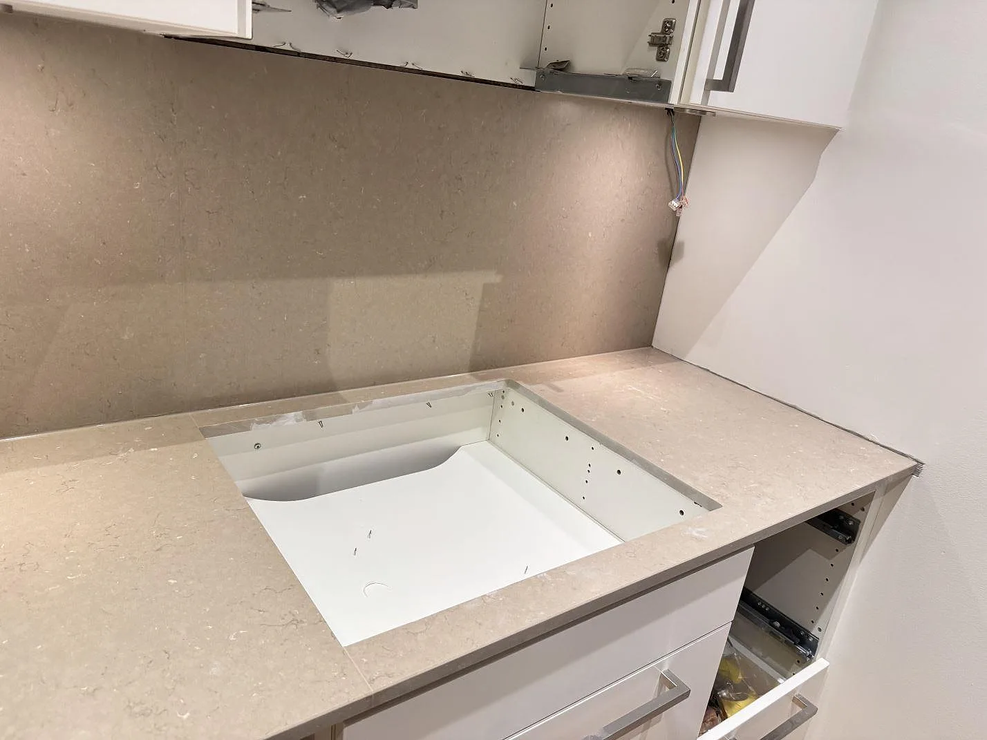 Silestone Coral Clay köksbänkskiva i matt Mocka med stort urtag förberett för vitvaror och matchande stänkskydd, kök under montering i Malmö.