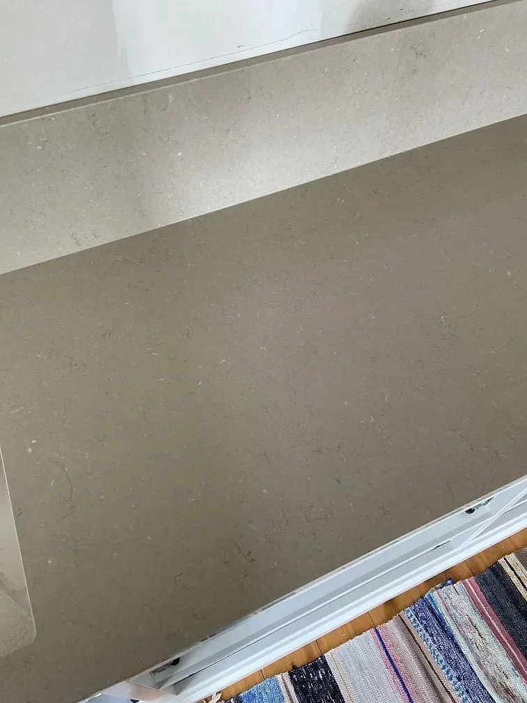 Greige Silestone Coral Clay bänkskiva med uppvikt stänkkant och blandarhål, kök mitt under installation i Mölltorp.