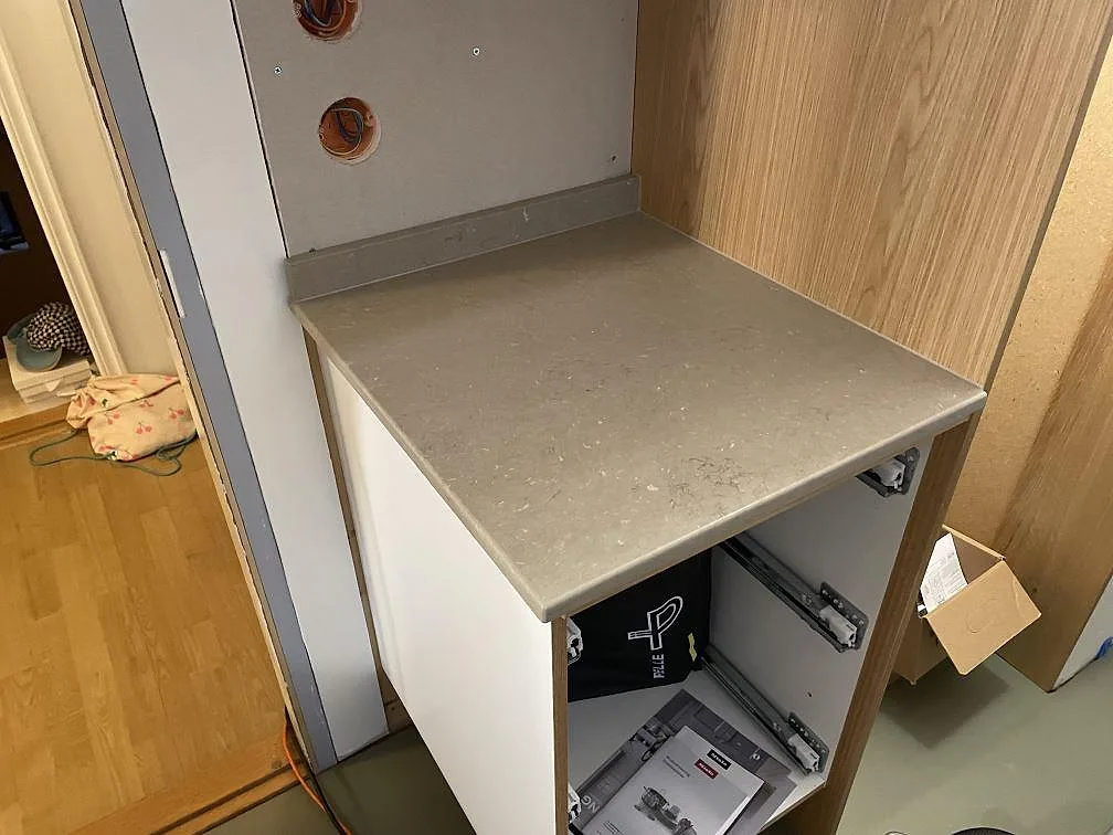 Kort bänkdel i matt Silestone Coral Clay, 20 mm kvartskomposit, med stänkkant vid högskåp i ett kök i Mölnlycke.