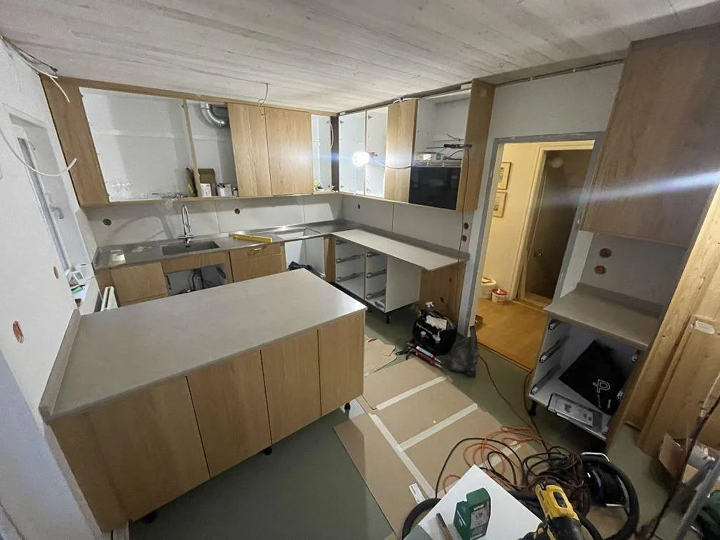 Översikt av kök i Mölnlycke med köksbänkskivor och köksö i matt Silestone Coral Clay, 20 mm, monterade mot träinredning.