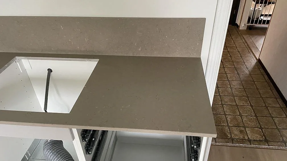 Arbetsyta i Silestone Coral Clay, matt kvartskomposit, med hällöppning och stänkskydd i ett kök i Nässjö.