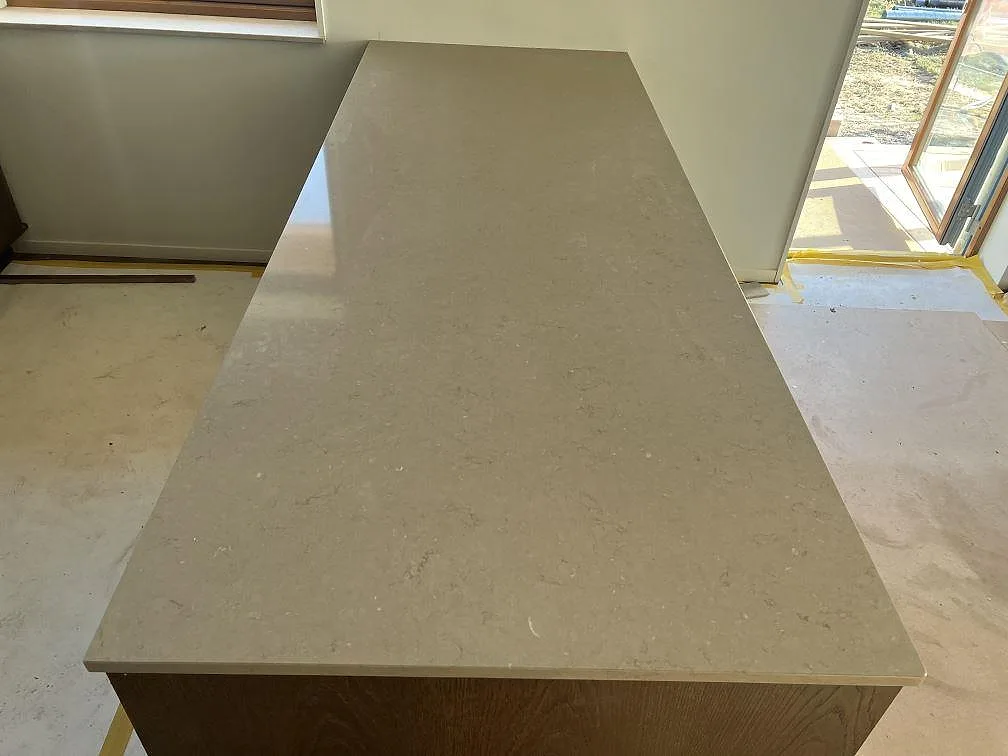 Köksö med polerad Silestone Coral Clay komposit i varm gråbeige ton i ett kök i Nättraby.