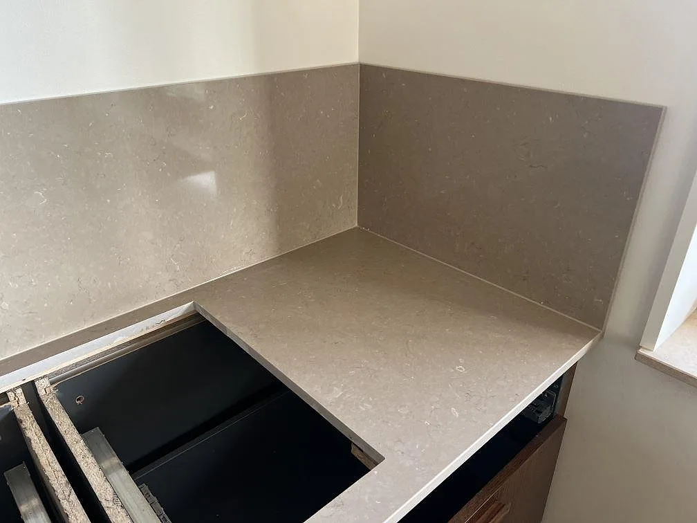 Hörndel av köksbänkskiva i Silestone Coral Clay med 12 mm stänkskydd och utskärning för häll i Nättraby.