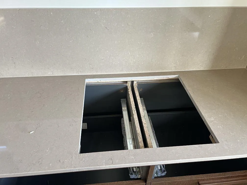 Polerad Silestone Coral Clay bänkskiva med hällöppning och matchande stänkskydd i kök i Nättraby.