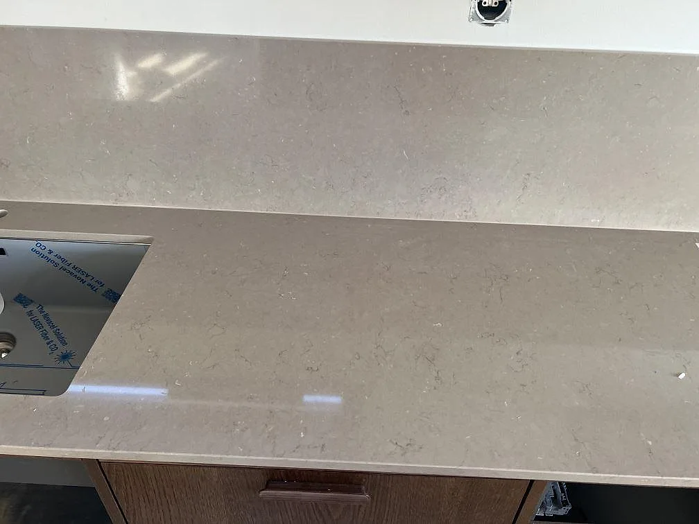 Rak köksbänk i polerad Silestone Coral Clay komposit med stänkskydd och valnötsbruna fronter i Nättraby.