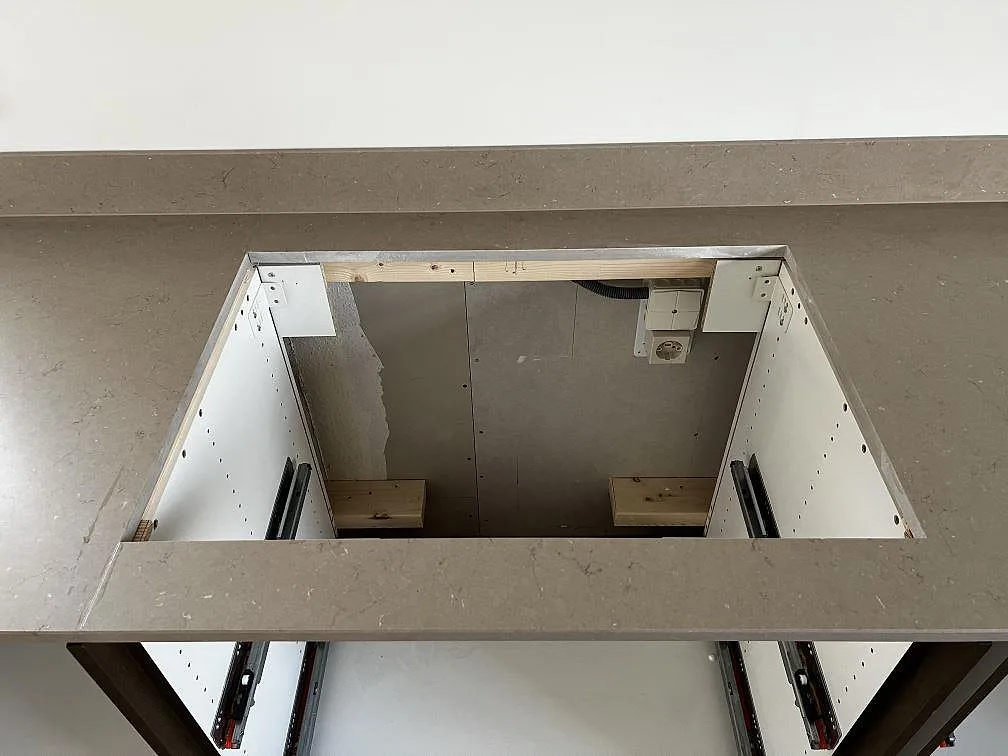 Detalj av utskärning i matt Silestone Coral Clay bänkskiva med öppen köksstomme under monteringen i Öckerö.