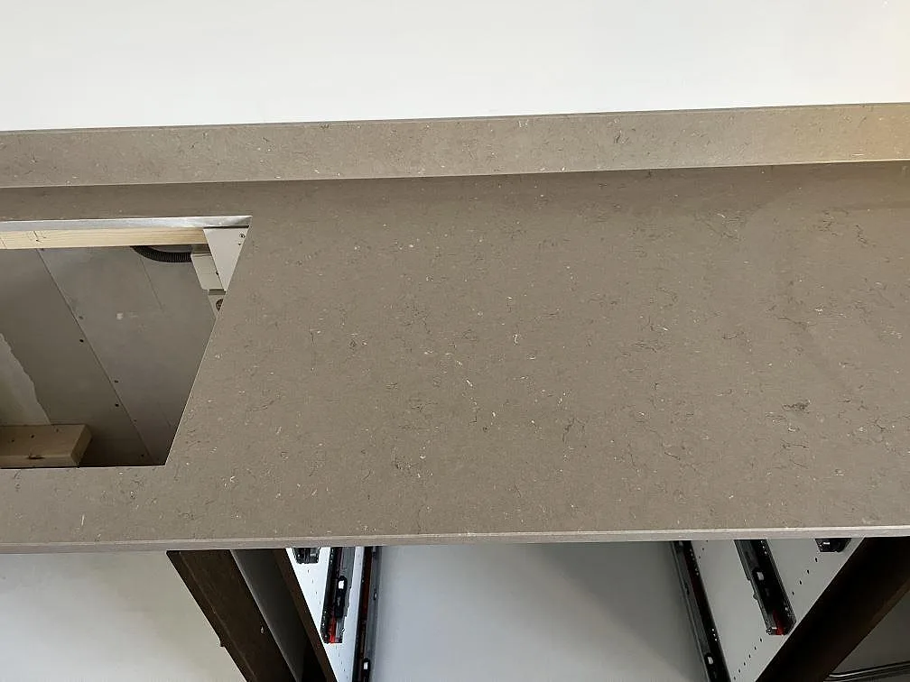 Matt Silestone Coral Clay bänkskiva med diskret mönstring, stänkkant och förberedd öppning i ett kök i Öckerö.