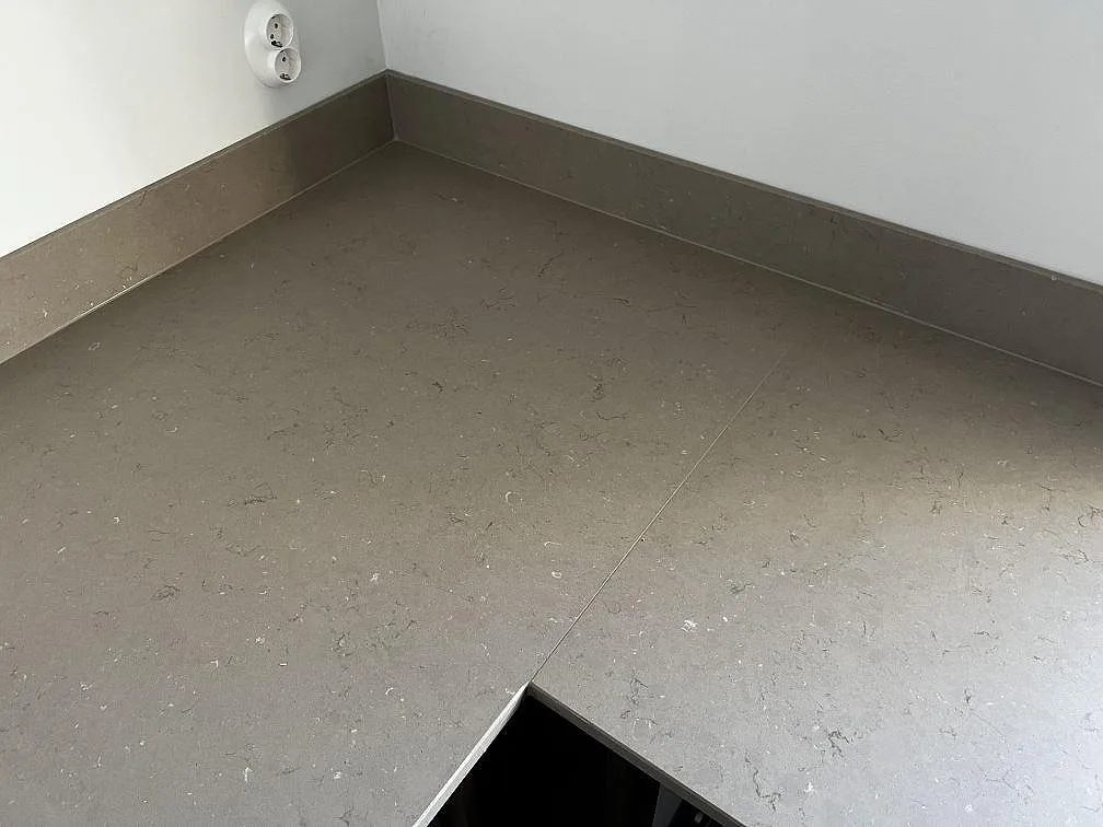 Hörndetalj i matt Silestone Coral Clay med stänkkant, skarv och utskärning i ett kök i Öckerö.