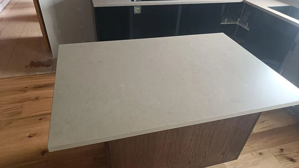 Närbild av köksö i Silestone Coral Clay med matt komposityta och träinredning i ett kök i Öckerö.