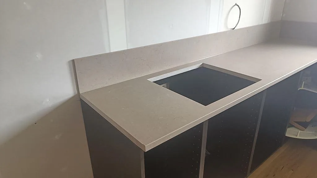 L-formad köksbänkskiva i Silestone Coral Clay, matt Mocka, med rektangulärt urtag och stänkskydd i Öckerö.