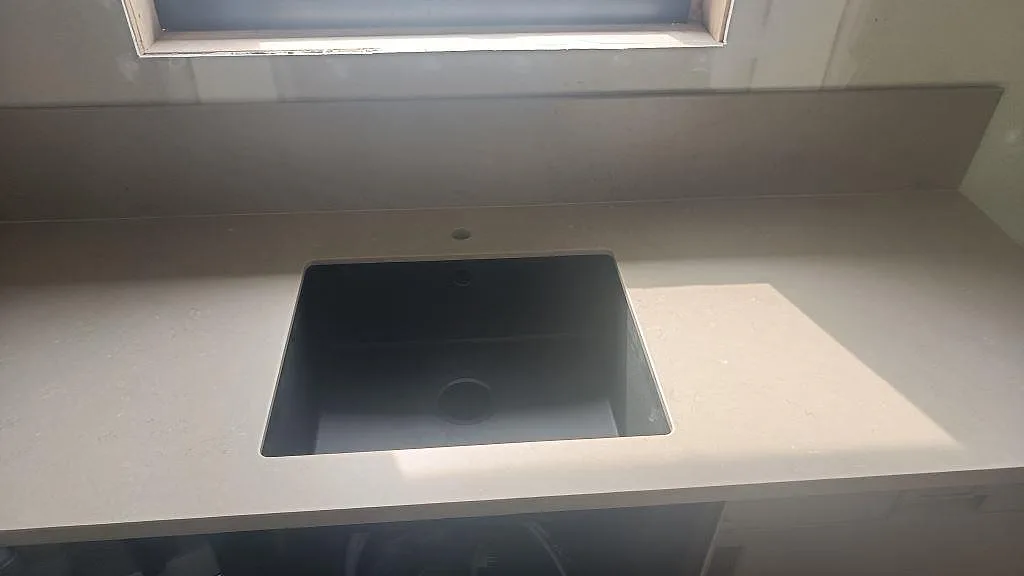 Bänkskiva i Silestone Coral Clay under fönster med rektangulär öppning och matt Mocka-yta i Öckerö.