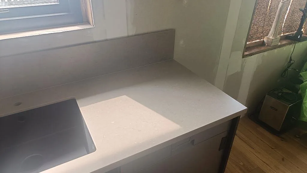 Höger bänkyta i Silestone Coral Clay med stänkskydd, matt finish och pågående köksmontering i Öckerö.