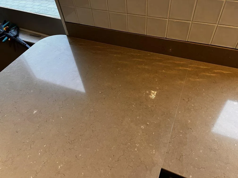 Närbild på polerad Silestone Coral Clay som köksbänkskiva med varm gråbeige ton och låg stänkkant i Oxie.