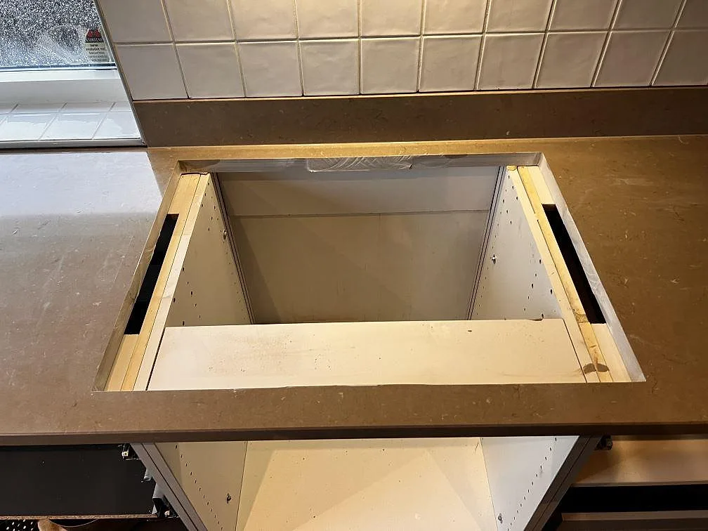 Håltagning för häll i polerad Silestone Coral Clay, 30 mm komposit, med stänkkant i ett kök i Oxie.