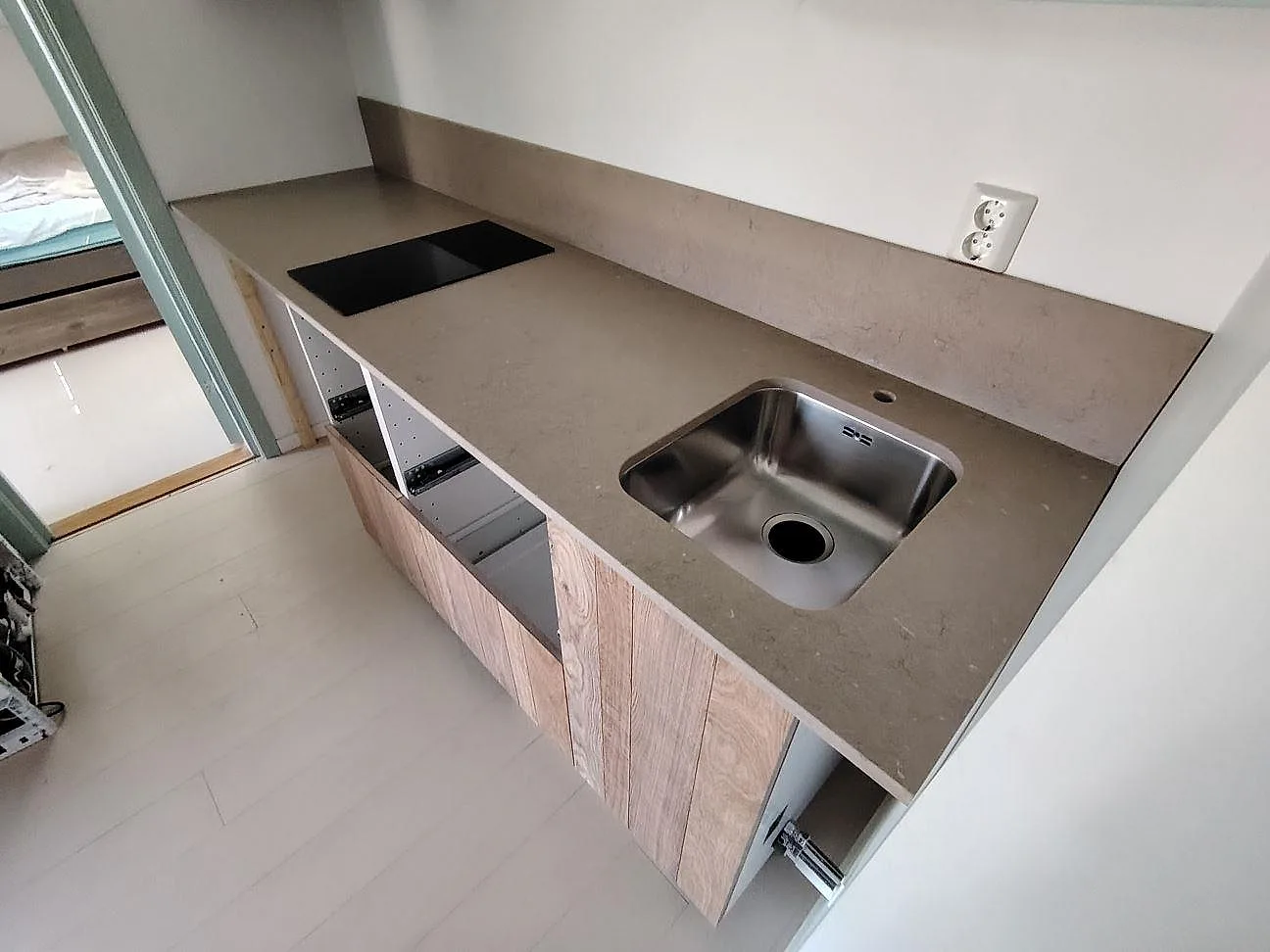 Köksbänkskiva i greige Silestone Coral Clay, matt Mocka, med underlimmad rostfri diskho, induktionshäll och stänkskydd i Sandhamn.
