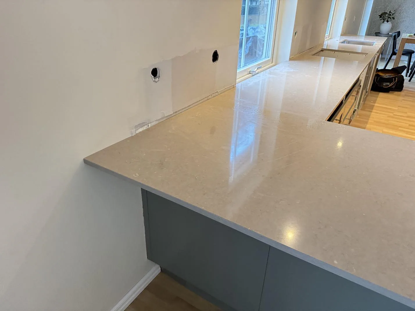 Köksbänkskiva i Silestone Coral Clay, polerad 20 mm komposit, längs vägg och fönster i Saxtorp.
