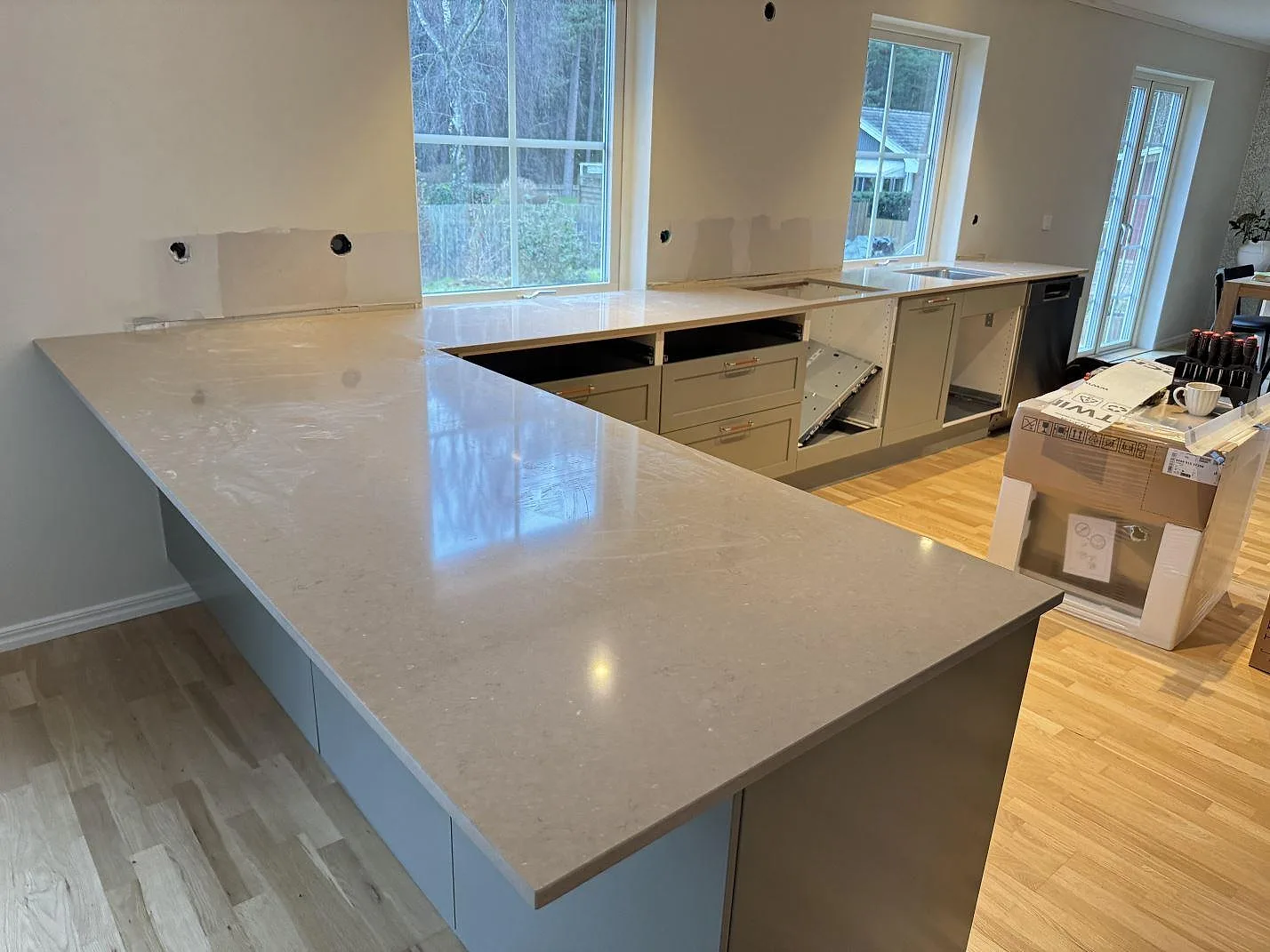 Köksbänkskiva i Silestone Coral Clay, polerad komposit, med bred arbetsyta och diskhoområde i ett kök i Saxtorp.