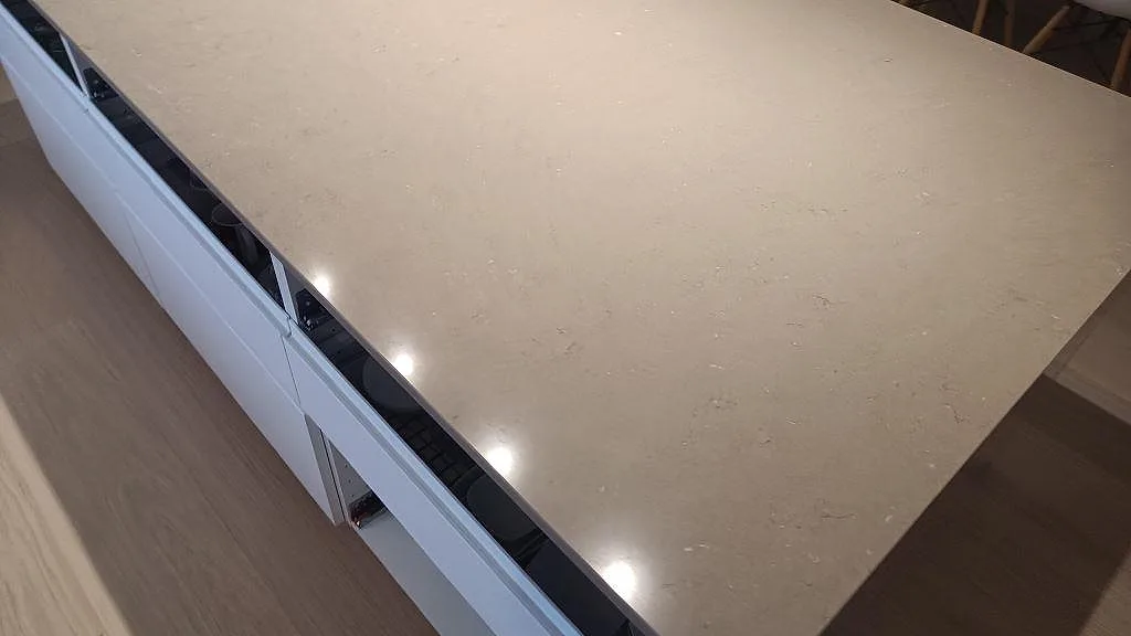 Detalj av köksöns blanka yta i Silestone Coral Clay, polerad ljus kvartskomposit, i Sjöbo.