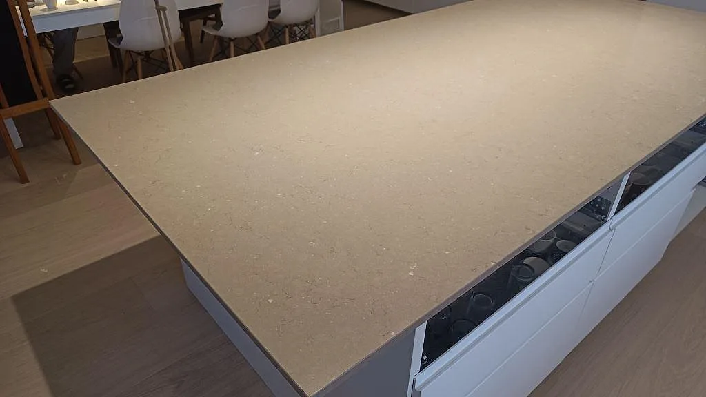Ytbild av polerad Silestone Coral Clay på köksö, med diskret korn och ljusa reflektioner i Sjöbo.