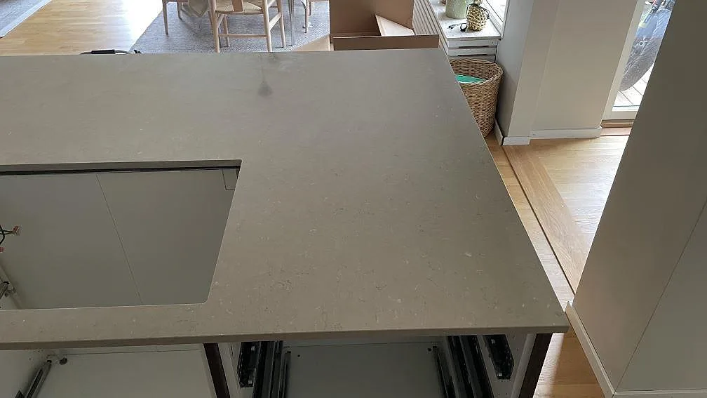 Polerad Silestone Coral Clay på köksö med ljus ådring och utskärning för häll i ett kök i Skanör.