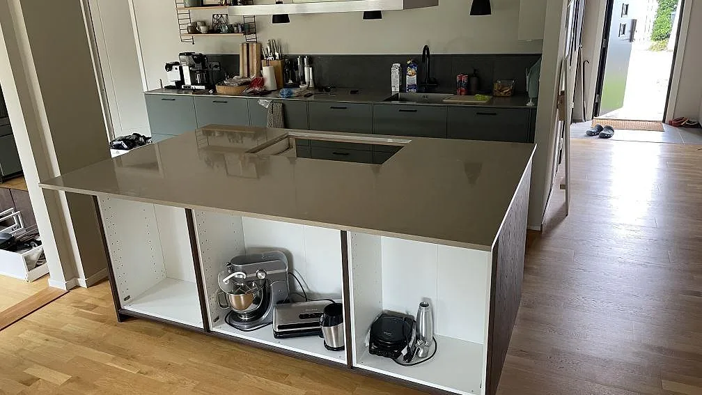 Köksö med köksbänkskiva i polerad Silestone Coral Clay, 20 mm, med häll i ett kök under montering i Skanör.