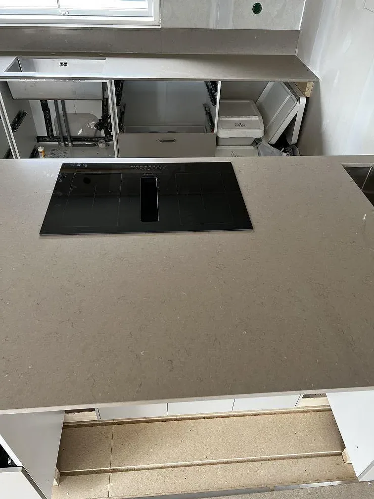 Köksbänkskiva i polerad Silestone Coral Clay med svart induktionshäll och synlig varm gråbeige struktur i Skövde.