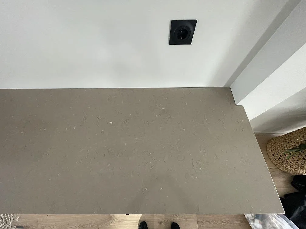 Närbild på den beige bänkskivan i polerad Silestone Coral Clay med diskret ådring i ett kök i Skogås.