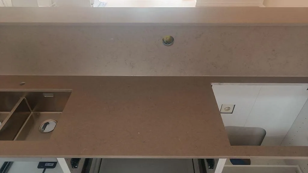 Närbild på köksbänkskiva i Silestone Coral Clay, matt kvartskomposit, med dubbelho, hällöppning och stänkskydd i Skurup.