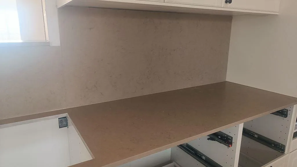 Rak bänkyta i Silestone Coral Clay med matt Mocka-finish och 12 mm stänkskydd under överskåp i ett kök i Skurup.