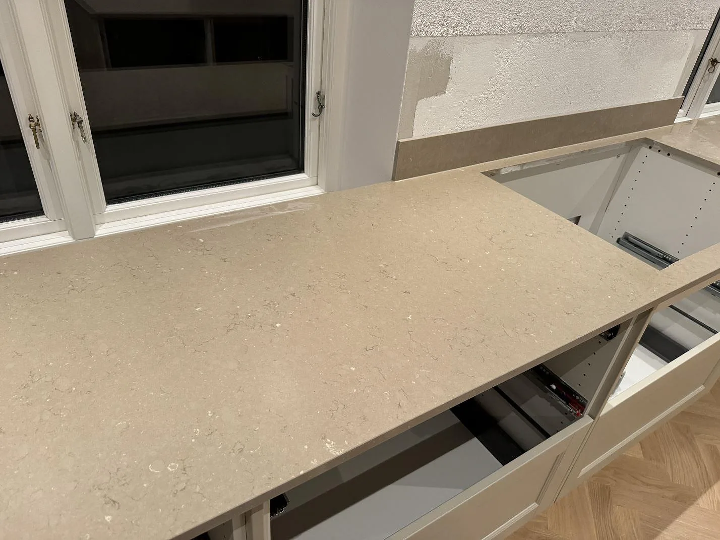 Silestone Coral Clay köksbänkskiva i komposit med 12 mm stänkskydd, rektangulär öppning och öppna köksstommar i Skurup.