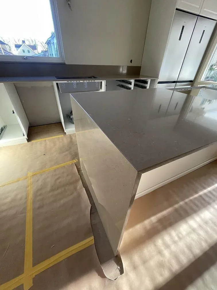 Gerad gavel på köksö i polerad Silestone Coral Clay komposit i ett kök i Sölvesborg.
