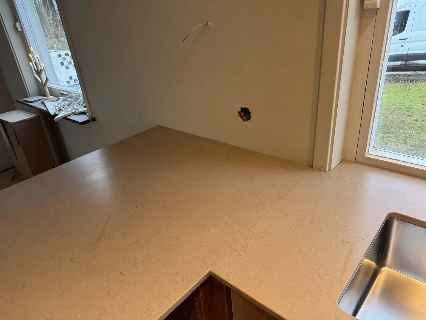 Köksbänkskiva i matt Silestone Coral Clay med synlig diskho och hällöppning under montering i Sösdala.