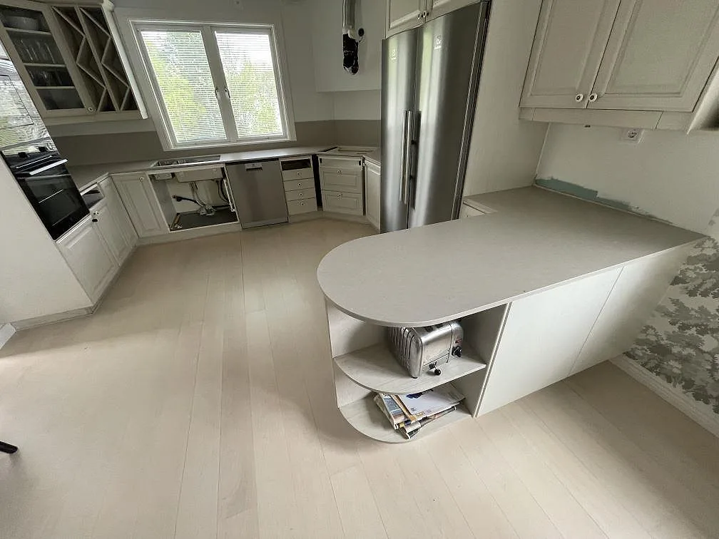 Köksbänkskiva och köksö i matt Silestone Coral Clay, 12 mm Mocka, med låg stänkkant i ett ljust kök i Sollentuna.