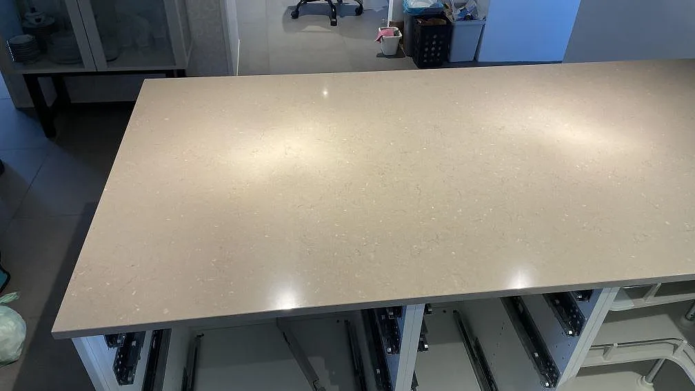 Topvy av polerad Silestone Coral Clay på en bred köksbänkskiva över halvön i Staffanstorp.