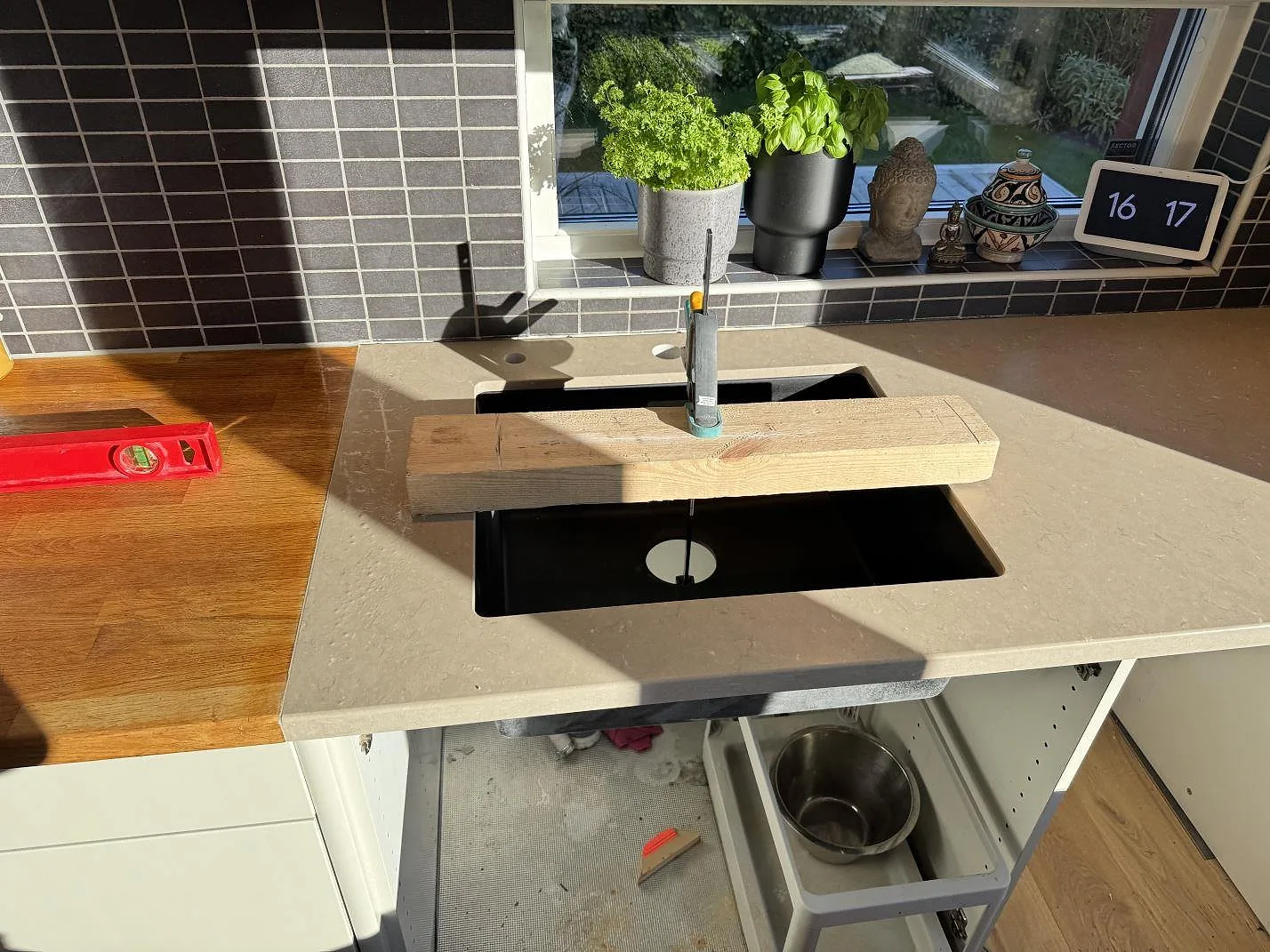 Detalj av Silestone Coral Clay kompositbänkskiva i matt Mocka-yta med synlig diskhoöppning och kaklad vägg i Staffanstorp.