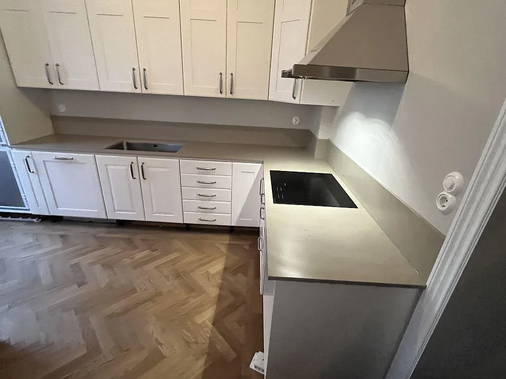 L-formad köksbänkskiva i gråbeige Silestone Coral Clay, matt Mocka, med underlimmad diskho och induktionshäll i Stockholm.