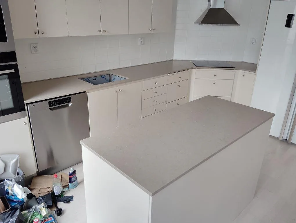 Köksbänkskiva och halvö i greige Silestone Coral Clay, matt Mocka-finish, monterade i ett vitt kök i Stockholm.