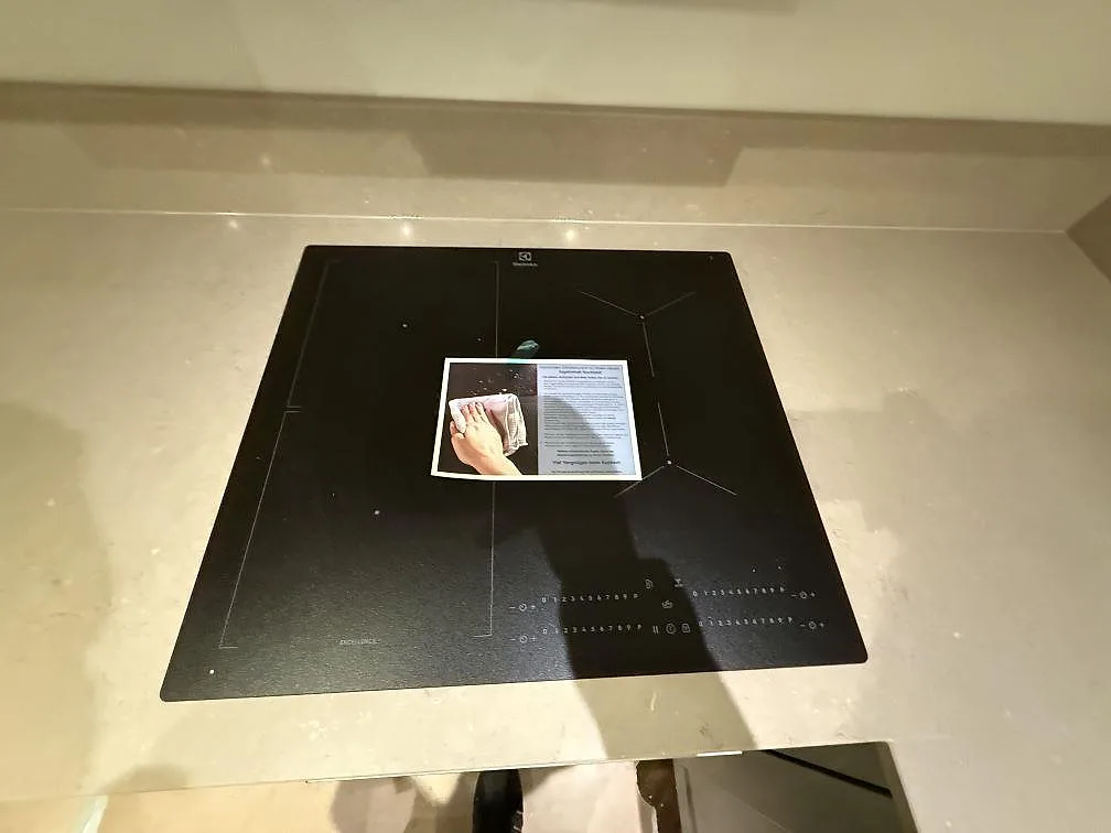Polerad köksbänkskiva i Silestone Coral Clay med svart häll och stänkkant i ett kök i Stockholm.