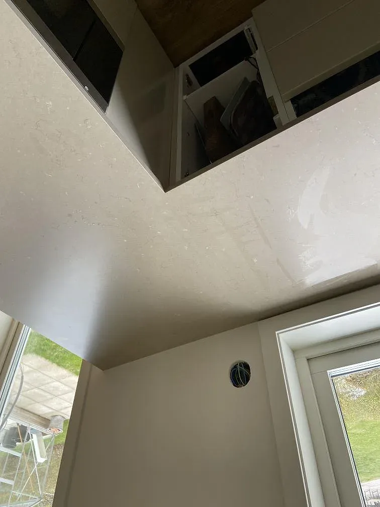 Underlimmad rostfri diskho infälld i en bänkskiva av Silestone Coral Clay i ett kök i Strömstad.
