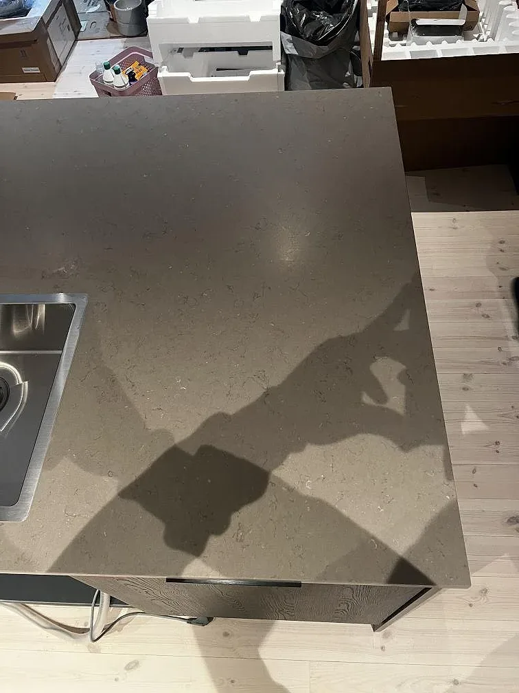 Ovanvy av Silestone Coral Clay bänkskiva med matt yta, rostfri diskho och ljus träpanel i Strömstad.