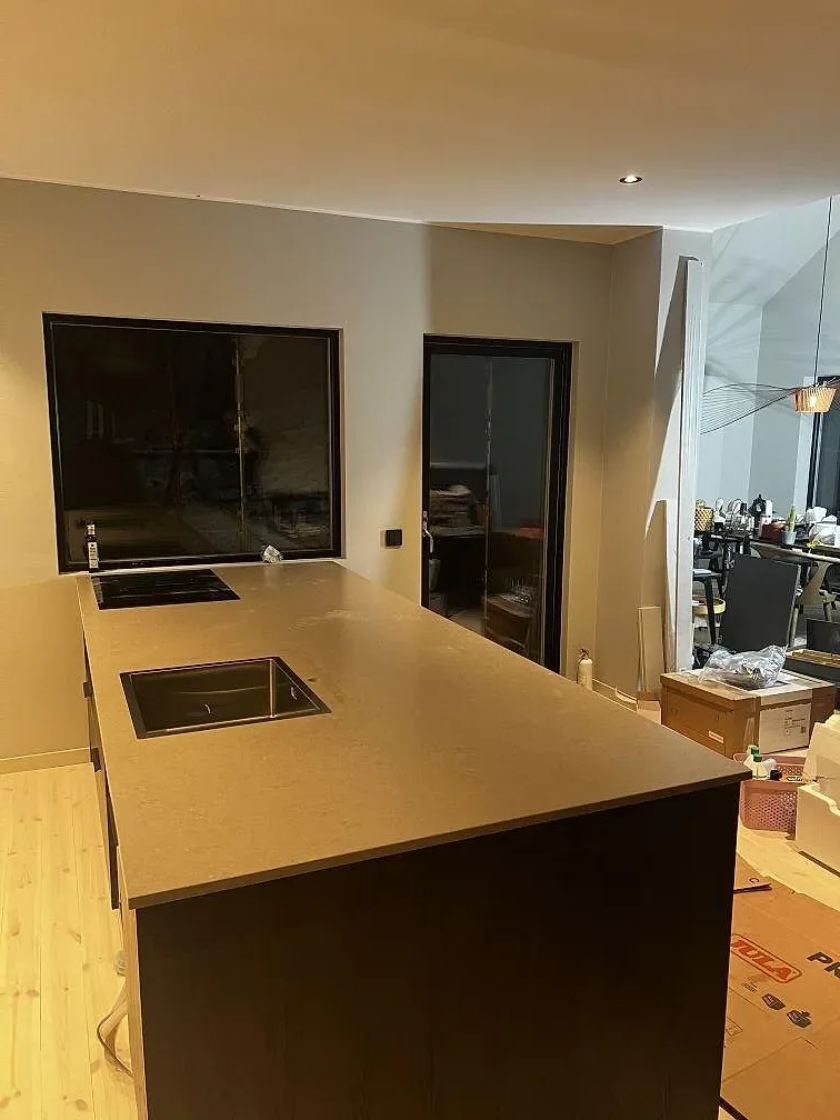 Köksbänkskiva i Silestone Coral Clay med matt Mocka-yta, rostfri diskho och svart induktionshäll i ett kök i Strömstad.