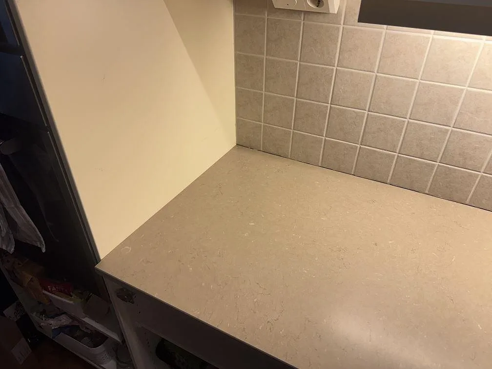 Installerad sidoyta i Silestone Coral Clay med matt Mocka-yta intill kakel och köksskåp i Strömstad.