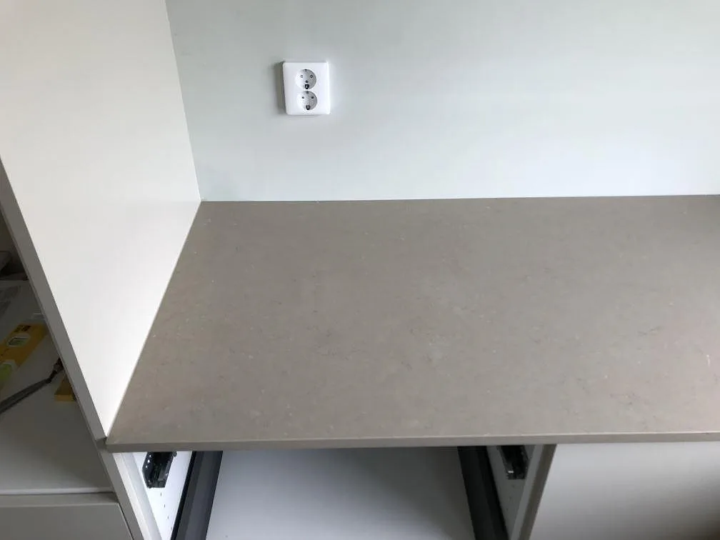 Polerad köksbänkskiva i Silestone Coral Clay med håltagning för häll, fotograferad uppifrån i ett kök i Svalöv.