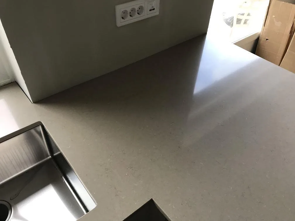 Polerad köksbänkskiva i Silestone Coral Clay med underlimmad rostfri diskho i ett kök under montering i Svalöv.