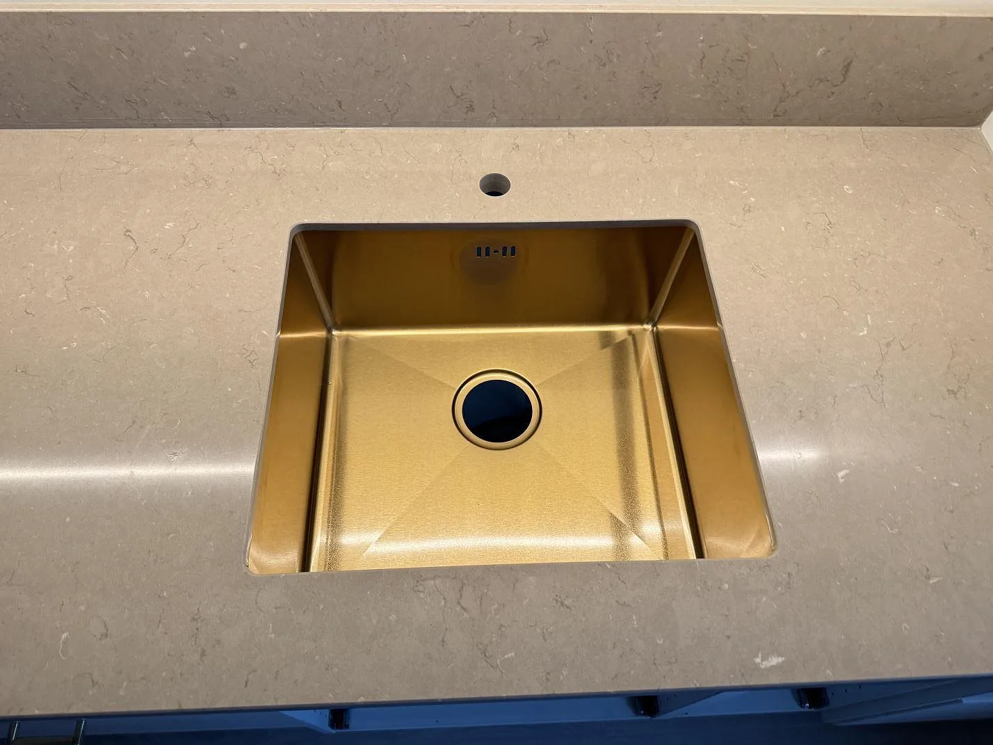 Ovanifrånbild av underlimmad diskho i en polerad Silestone Coral Clay köksbänkskiva med låg stänkkant i Svedala.