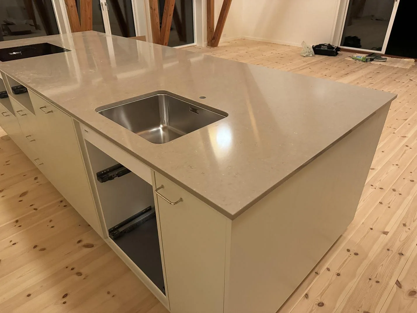 Köksö med 20 mm polerad Silestone Coral Clay i kvartskomposit, underlimmad rostfri diskho och häll i ett kök i Svendborg.