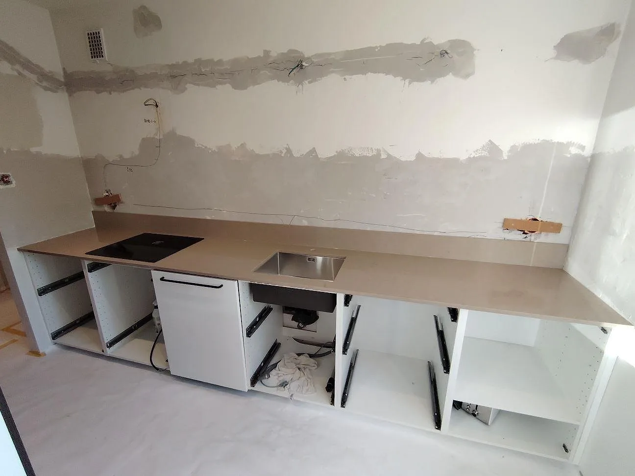 Rak köksbänkskiva i polerad Silestone Coral Clay komposit med häll och rostfri diskho i ett kök i Täby.