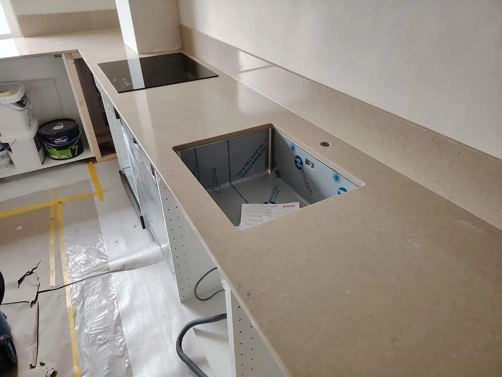 Närbild på Silestone Coral Clay som köksbänkskiva i kvartskomposit i Täby, med Polerad och Mocka enligt ordern, diskhoöppning, häll och matchande stänkskydd.