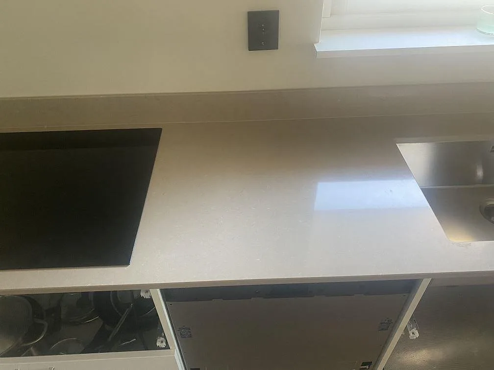 Köksbänkskiva i Silestone Coral Clay med infälld häll och underlimmad rostfri diskho i ett kök i Trelleborg.