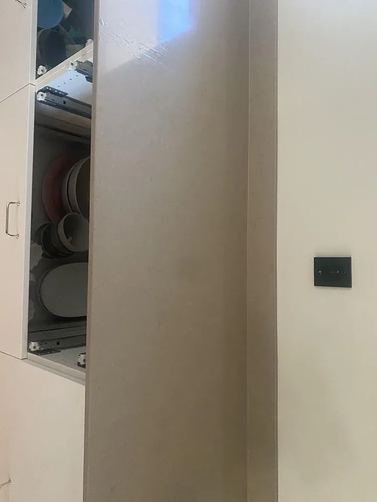 Polerad Silestone Coral Clay köksbänkskiva med låg uppvikt stänkkant mot väggen i ett kök i Trelleborg.